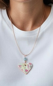 Necklace with a heart-shaped pendant featuring floral design on a white background