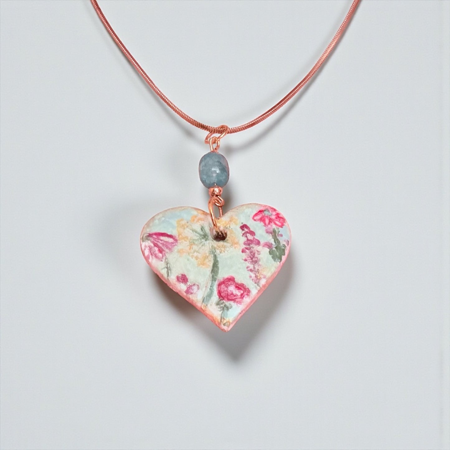 Heart-shaped floral pendant on a white background